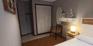 圣维森特-德拉巴尔克拉Apartamento a 30 metros de la playa的一间卧室配有一张床、一把椅子和镜子