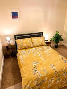 伦敦Master Kensington Gardens Apartments的一间卧室配有一张黄色棉被的床