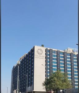 斋浦尔Balconies & Venue ( The Grand Anukampa)的一座高大的建筑,旁边有一个标志