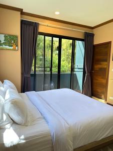 卡塔海滩Kata Noi Place的卧室设有一张白色大床和一扇窗户。