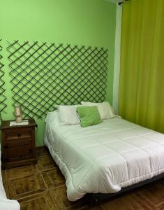 雷阿尔城Hostal Cabañeros的一间卧室配有一张带绿色墙壁的床
