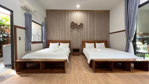 富国Nhu Huose Phu Quoc的一间卧室设有两张床和窗户。