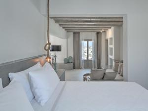 纳乌萨帕帕达克斯酒店的一间带白色床的卧室和一间客厅