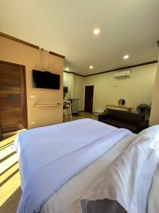 卡塔海滩Kata Noi Place的卧室配有一张白色的大床和一张沙发。