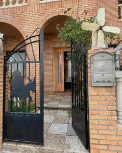 雷阿尔城Hostal Cabañeros的黑色的大门,上面有一条黑色的狗