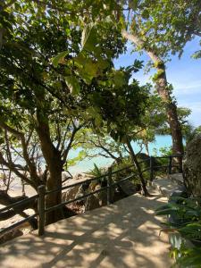 卡塔海滩Kata Noi Place的树木繁茂的海滩旁的木栅