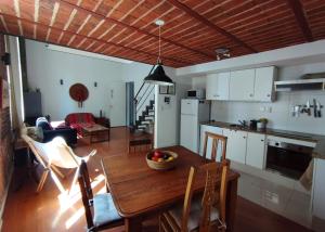 蒙得维的亚Zabalita, hermoso y cálido loft en la Ciudad Vieja的厨房以及带木桌和椅子的客厅。
