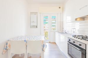 斯波托尔诺Appartamento vista mare di Marco的白色的厨房配有桌椅