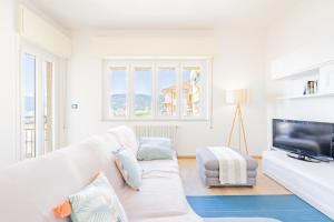 斯波托尔诺Appartamento vista mare di Marco的客厅配有白色沙发和电视