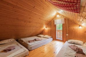 博德森特克Rudnica Hill Lodge - Happy Rentals的木制客房内的一间卧室配有两张床