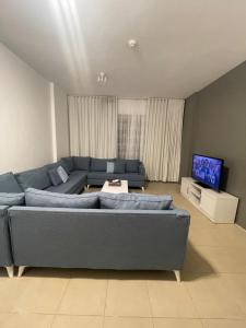 阿卜杜勒国王经济城مارينا KAEC的客厅配有蓝色的沙发和电视