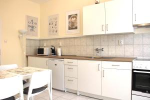 采格莱德Panoráma Apartman的厨房配有白色橱柜和桌子