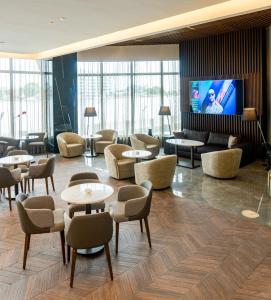 拉各斯Black Diamond Hotel的大堂设有桌椅和平面电视。
