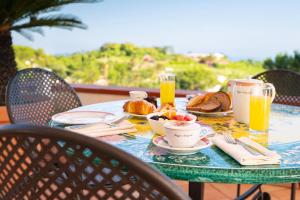 伊斯基亚波焦阿拉格斯特Spa酒店 的阳台上的桌子上摆着早餐食品和饮料