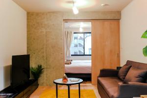 东京Seirai Asakusa Vacation Rental - 3 minutes from station的客厅配有沙发和1张床