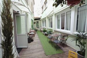 亚眠圣路易斯酒店的一个带桌椅的户外庭院和绿色地毯。