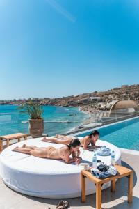 天堂海滩New Paradise Beach Resort的一群人躺在泳池旁的可拉式床上