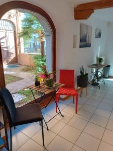 阿奎莱亚Amnis的客厅配有桌子和红色椅子
