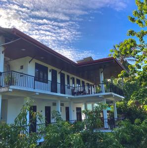 波隆纳鲁沃Hotel Siyathma polonnaruwa的带阳台和树木的白色建筑