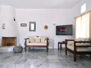 MárpissaAmelie Villa with pool and amazing sea views, Paros的带沙发和电视的客厅