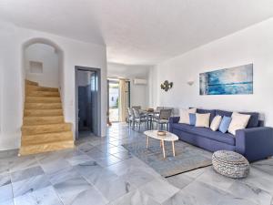 MárpissaAmelie Villa with pool and amazing sea views, Paros的客厅配有蓝色的沙发和桌子