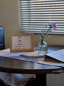 吕德里茨Seabreeze Accommodation的花瓶上的桌子和标志