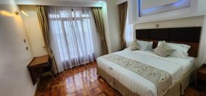 ShameneiAngani Resorts & Spa Limited的一间卧室设有一张大床和一个大窗户