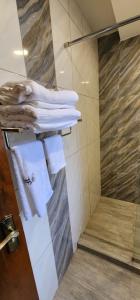 ShameneiAngani Resorts & Spa Limited的带淋浴和白色毛巾的浴室