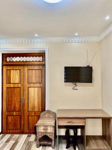 布哈拉阿拉奔酒店的一间设有门的房间和墙上的电视