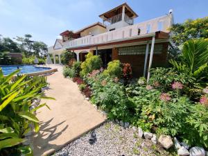 Amphoe KumphawapiBua Daeng Homestay Resort的一座带花园和游泳池的房子