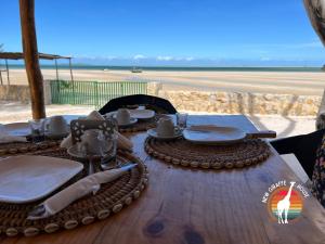 维兰库卢什New Giraffe House的海滩顶部一张带盘子和餐具的木桌
