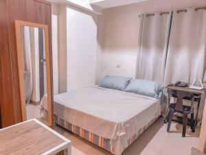 宿务Chillhauz Staycation Cebu的一间小卧室,配有一张床和一张书桌