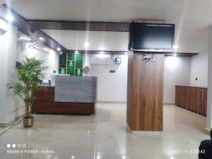 瑞诗凯诗Hotel Mahadev Rishikesh的一间墙上配有电视和书桌的房间