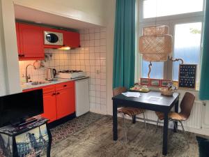 西泰尔斯海灵Riposo的厨房配有红色橱柜和桌椅
