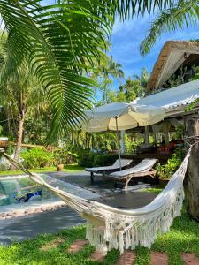 象岛Maddekehaoo Eco Mansion的度假村前的吊床,带游泳池