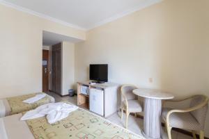 累西腓Flat Costa Mar的客房设有1张床、1张桌子和1台电视。