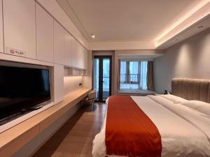 深圳凯森希悦酒店公寓(深圳国际会展中心店)的一间卧室配有一张大床和一台平面电视