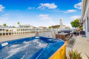 马特里查Hot tub and Dock Gilligan's on the Island的阳台的热水浴池,配有桌椅