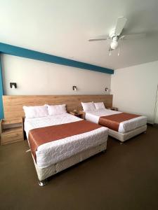 伊洛Costa Bella的一间卧室配有两张床和吊扇
