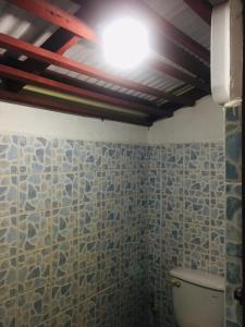 Siboya拉查日落度假酒店的一间带卫生间的浴室和天花板上的灯