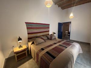 圣佩德罗·德·阿塔卡马考艾阿塔卡马旅馆的一间卧室配有一张大床和一张边桌