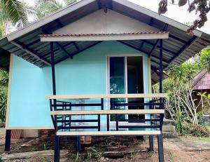 Siboya拉查日落度假酒店的前面有长凳的蓝色房子