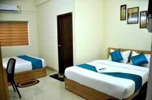 科泽科德MARHABA PALACE的一间卧室配有两张带蓝白色床单的床