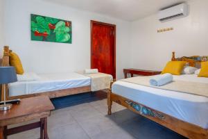 托尔图格罗La Casona Eco-Lodge Tortuguero的客房设有两张床、一张桌子和一张桌子。