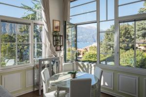 贝拉吉奥Bellagio Vintage Apartment的一间设有大窗户和桌椅的用餐室
