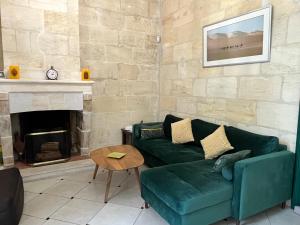 波尔多Aquitain Home Gare Saint Jean的客厅设有绿色沙发和壁炉