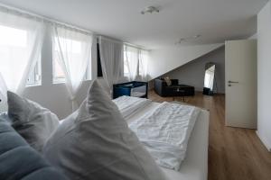 PlankstadtApartment im Dachgeschoss的一间带白色床的卧室和一间客厅