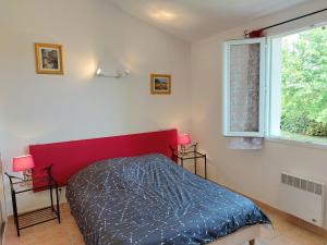 BessasVillage de gîtes La Fontinelle的一间卧室设有红色的床和窗户。