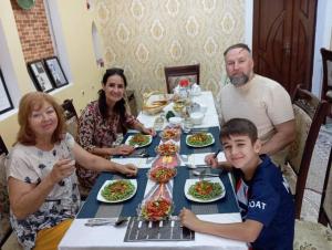 希瓦Khiva Ibrohim Guest House的一群坐在桌子旁吃食物的人