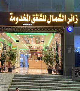 哈伊勒فندق زائر الشمال的建筑前有标志的商店